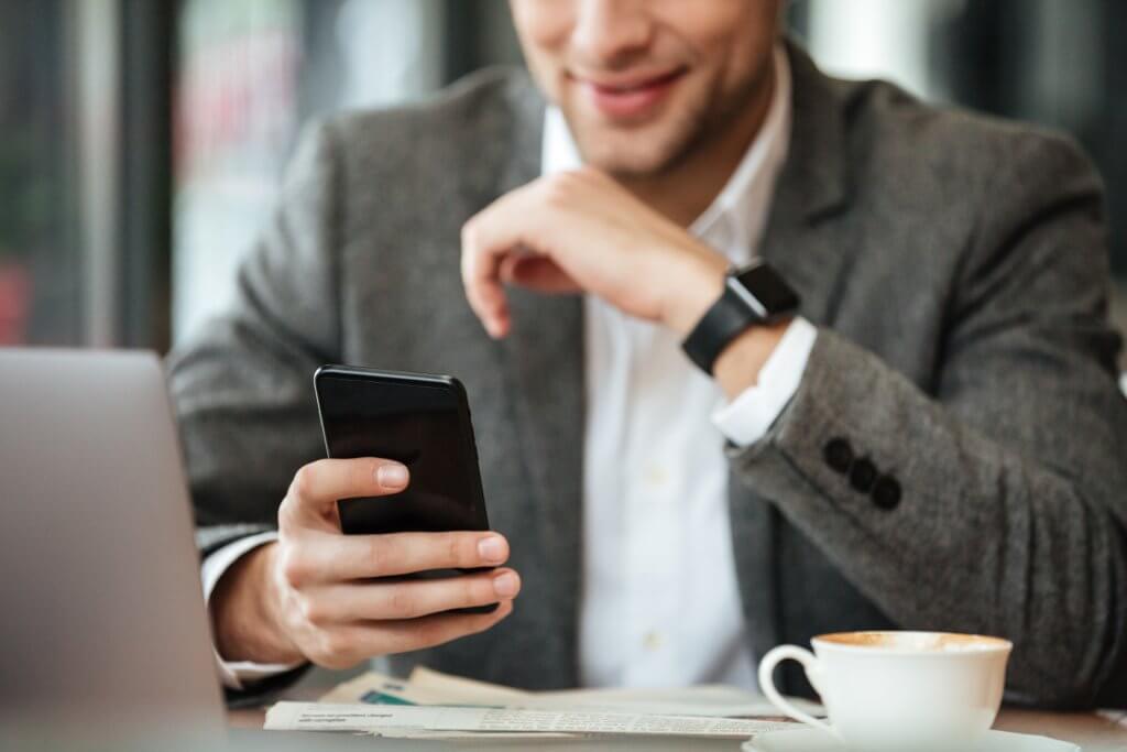 Cropped image of happy business man sitting by the table